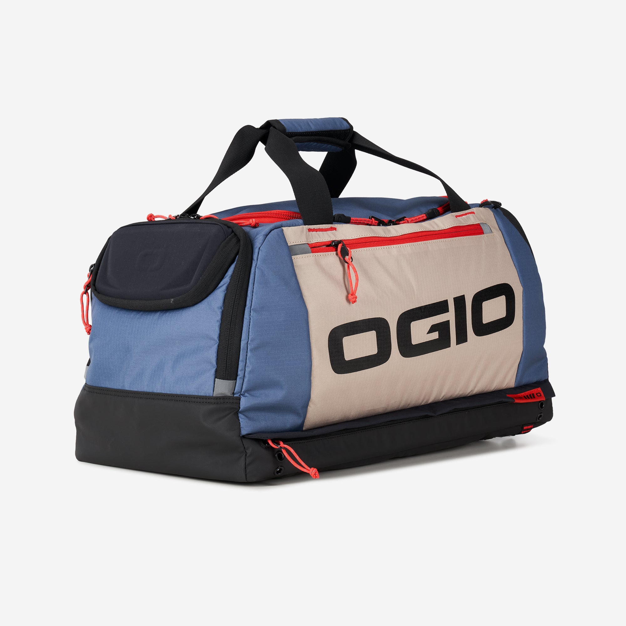 A multi-functional fitness duffel bag in tan, blue, and red colors with the OGIO brand logo displayed prominently. It has multiple compartments and carry handles.